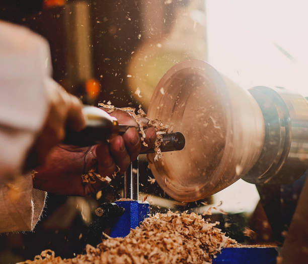 man using a woodturning lathe to make a wooden bowl